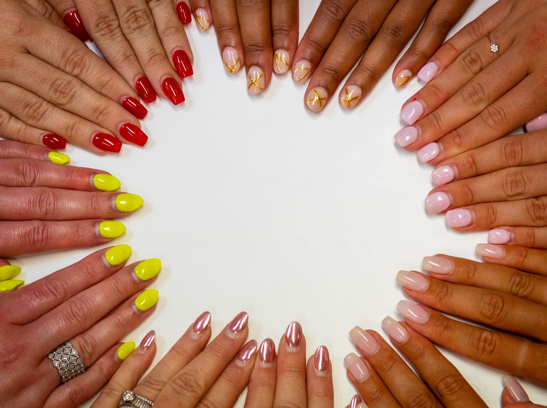 Fingernails and nail art. Diverse women with rainbow of painted nails. Acrylic, gel, shellac, polish, varnish, metallic manicure.