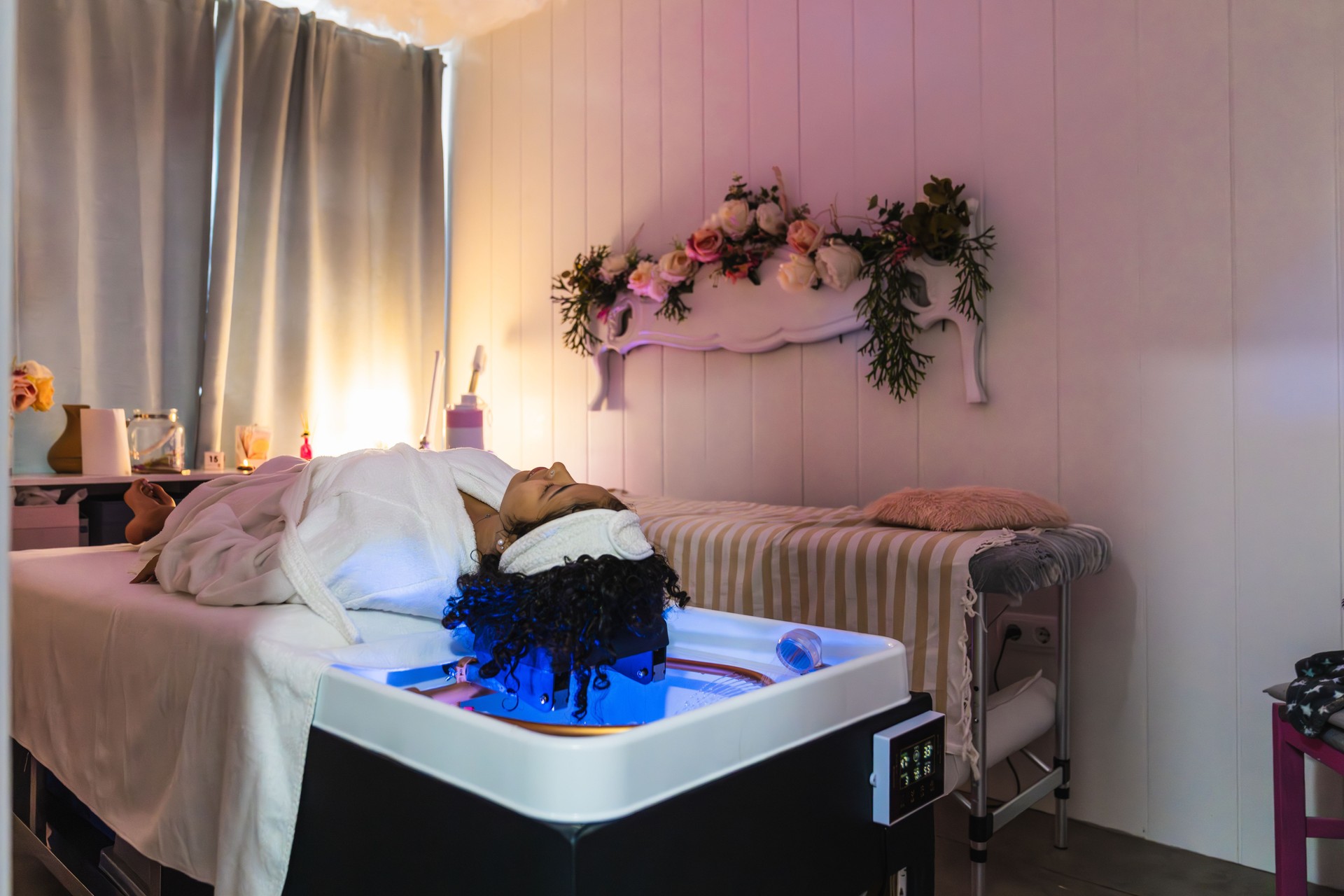 Young woman relaxing during innovative pressurized water hair treatment in beauty salon